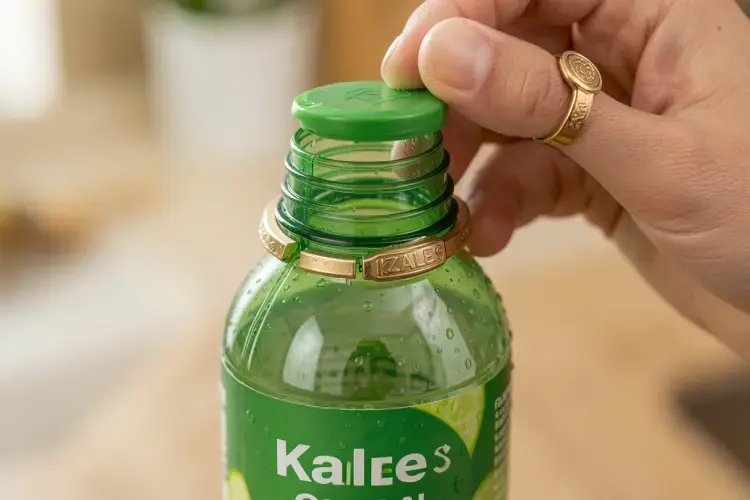 detail cincin segel otomatis yang terputus pada leher botol kale saat pertama kali dibuka oleh konsumen. alt mekanisme tutup segel otomatis botol kale plastik