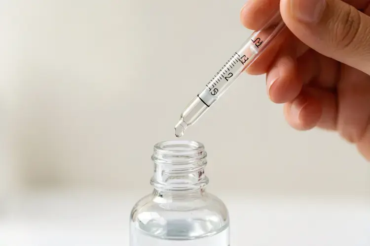 pengujian daya hisap cairan menggunakan pipa kaca berskala pada botol pipet kosmetik. alt pengujian presisi botol pipet serum kosmetik